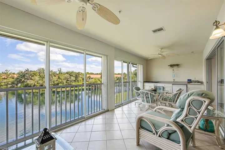 Sunroom / solarium with a water view, sink, and ceiling fan