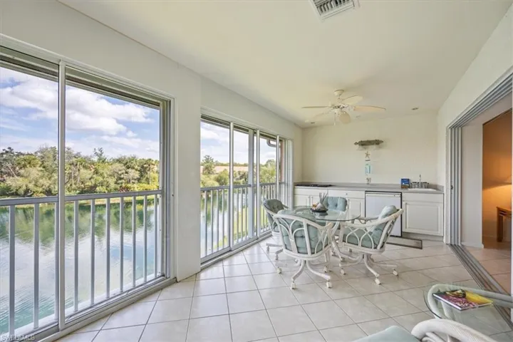 Sunroom / solarium with a water view, sink, and ceiling fan
