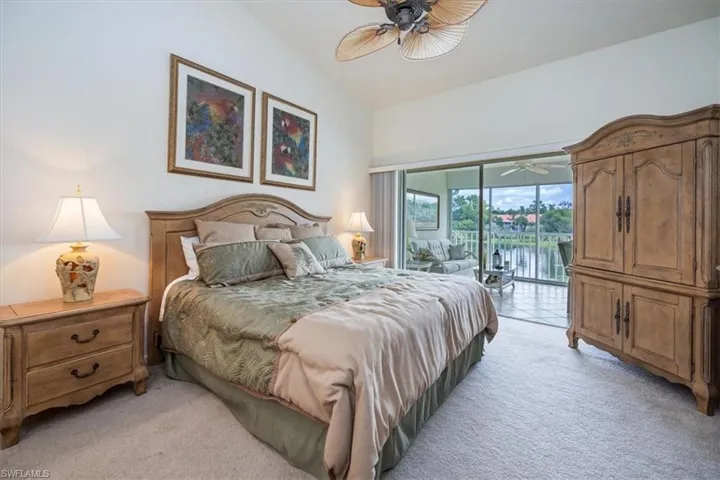 Carpeted bedroom with lofted ceiling, ceiling fan, and access to exterior