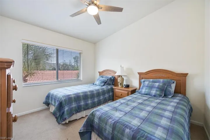 Bedroom with light carpet, vaulted ceiling, and ceiling fan
