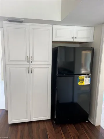 Detailed view of paneled built in refrigerator and wood finished floors