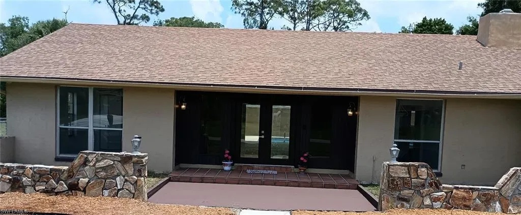 Entrance to property featuring french doors, stucco siding, and a shingled roof