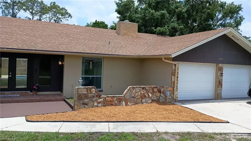 Single story home with a shingled roof, a chimney, a garage, concrete driveway, and stucco siding