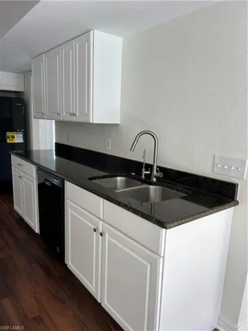 Kitchen featuring dishwasher, dark wood-style floors, white cabinets, and refrigerator