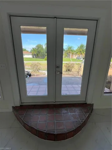 Doorway to outside featuring marble look tile flooring