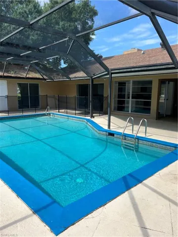 View of pool with a patio and glass enclosure