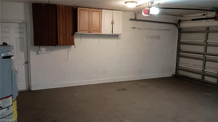 Garage featuring water heater and a garage door opener