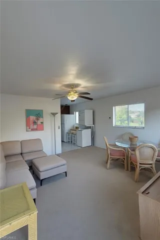 Living room with carpet and ceiling fan