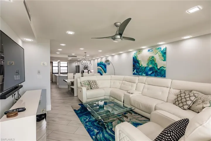 Living area with a ceiling fan, wood tiled floors, and suspended lighting