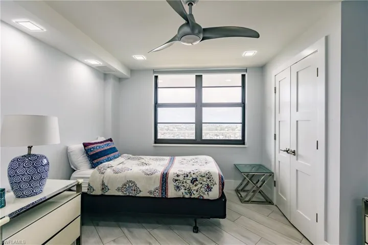 Bedroom featuring wood tiled floors, ceiling fan, and a closet