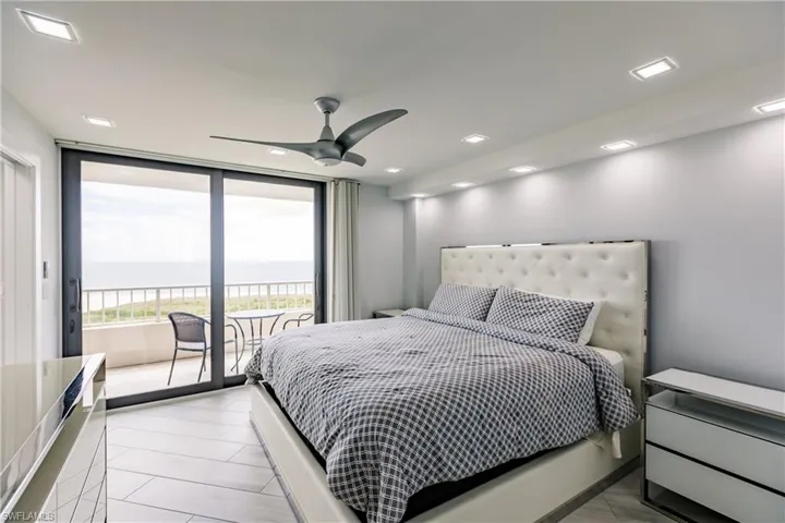 Bedroom with a water view, access to outside, ceiling fan, recessed lighting, and floor to ceiling windows