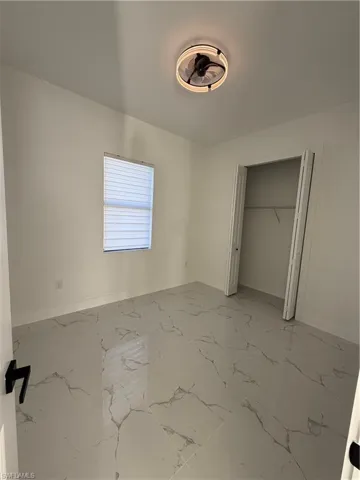 Unfurnished bedroom featuring baseboards and a closet