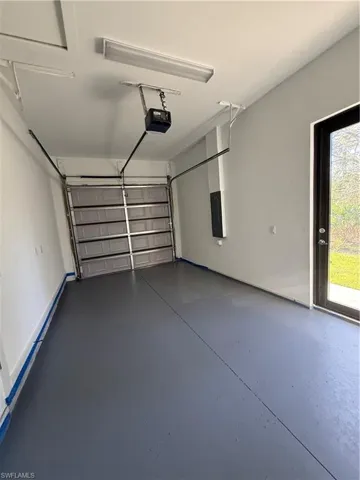 Garage featuring a garage door opener and electric panel