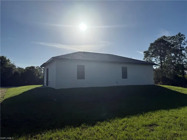 View of side of home with a yard and stucco siding