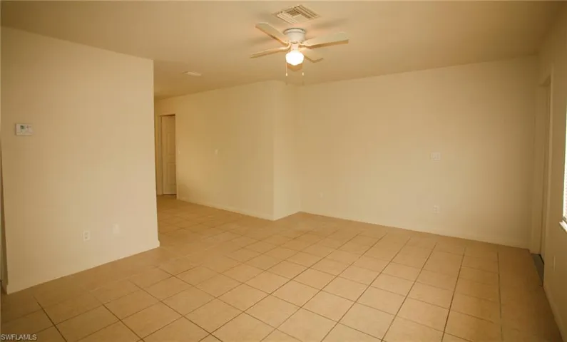 Unfurnished room with ceiling fan and baseboards