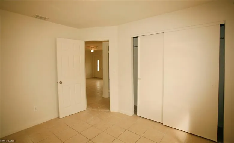 Unfurnished bedroom featuring a closet and light tile patterned floors