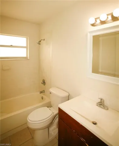 Full bathroom featuring vanity, washtub / shower combination, and light tile patterned flooring