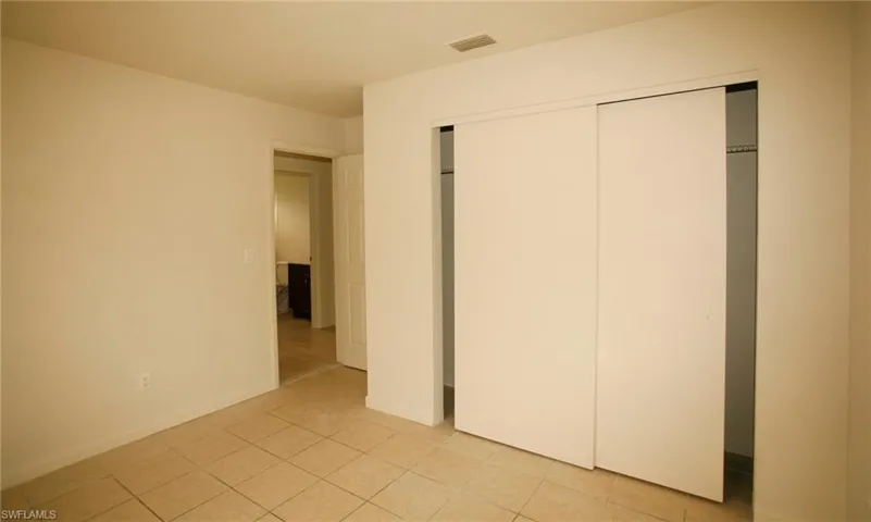 Unfurnished bedroom featuring a closet and light tile patterned floors