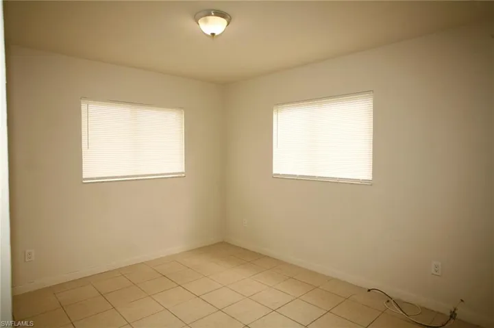 Unfurnished room with baseboards and light tile patterned flooring