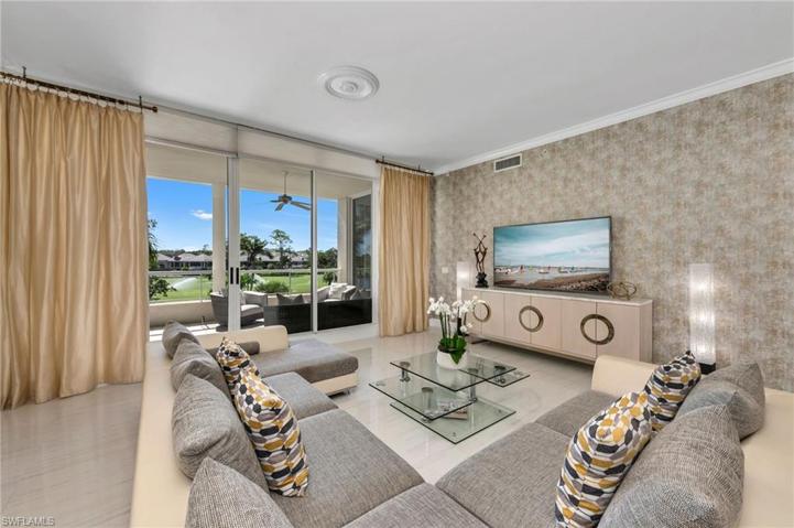 The living room overlooks the lanai with views of the lake, golf course and the Clubhouse.