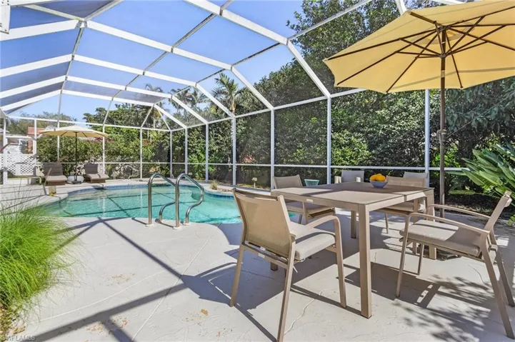 Outdoor pool with a patio and glass enclosure
