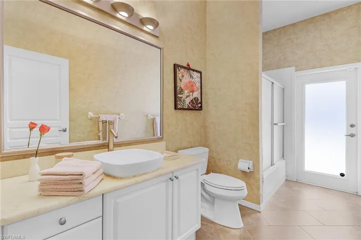 Bathroom with vanity, enclosed tub / shower combo, and tile patterned floors
