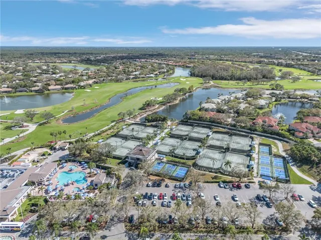 Aerial view of property's location featuring a golf club, a large body of water, and nearby suburban area
