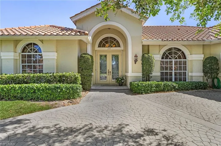 View of exterior entry featuring french doors, a tiled roof, and stucco siding