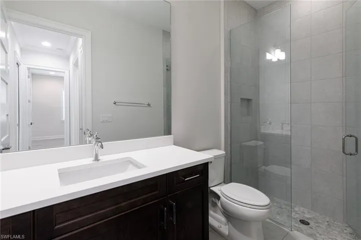 Full bath with toilet, vanity, and a stall shower