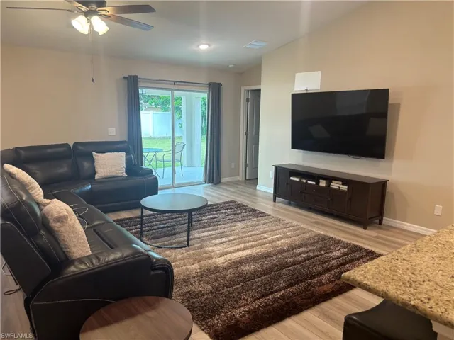 Living area with light wood-style flooring and ceiling fan