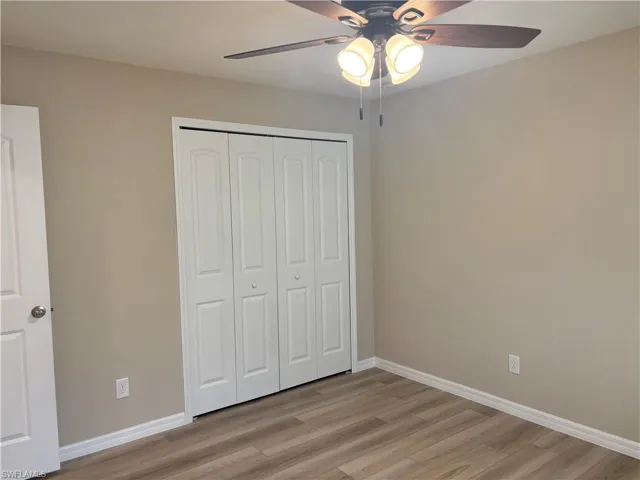 Unfurnished bedroom featuring light wood-style flooring, a closet, and ceiling fan