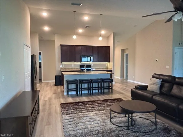 Living area with light wood finished floors, ceiling fan, and recessed lighting