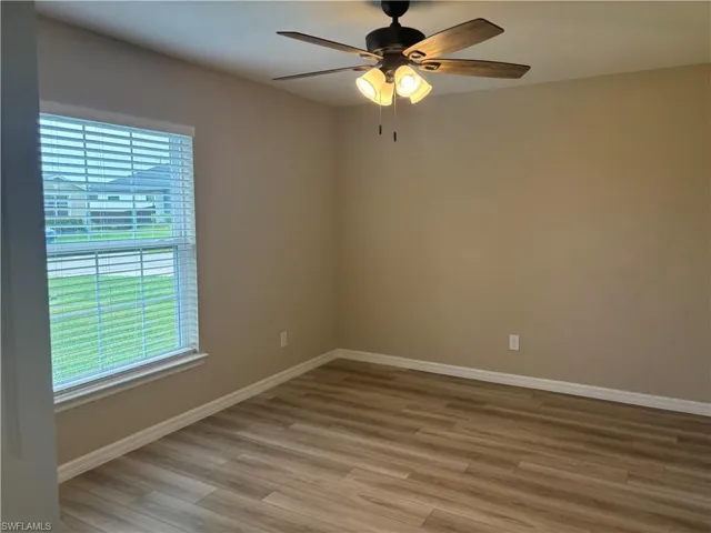 Spare room with light wood finished floors and ceiling fan