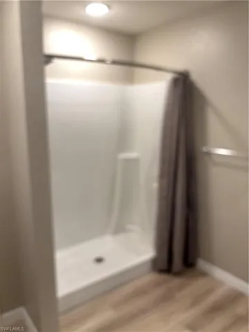 Bathroom with light wood finished floors and a shower stall