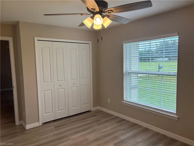 Unfurnished bedroom with a ceiling fan, a closet, and light wood-style floors