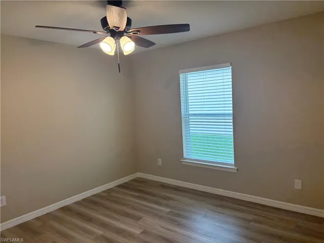 Spare room with wood finished floors and ceiling fan
