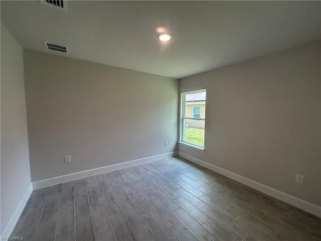 3rd Bedroom Reaturing Wood Look Tiled Floors and 5 1/4" Baseboards