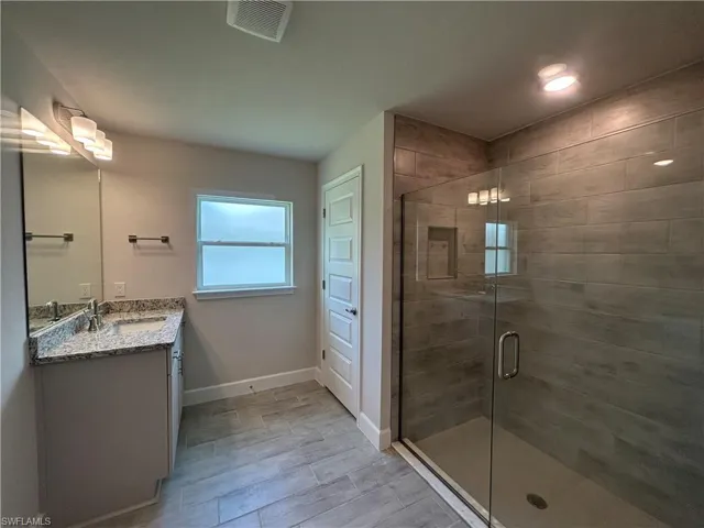Bathroom with Vanity, Walk In Shower, and Wood Look Ceramic Tiled Floors