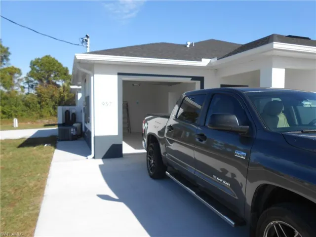 View of property exterior with concrete driveway, an attached garage, and stucco siding
