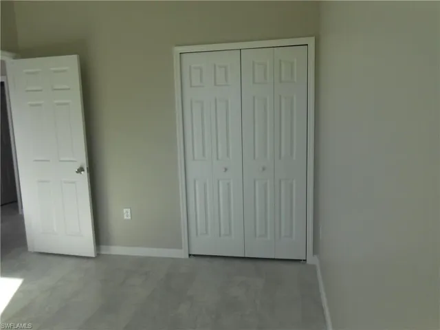 Unfurnished bedroom featuring baseboards and a closet