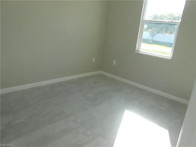Spare room with baseboards and light floors