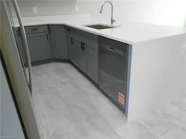 Laundry room with a sink and light floors