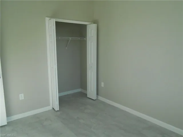 Unfurnished bedroom with a closet and baseboards