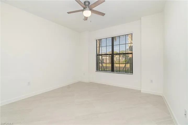 Empty room featuring baseboards and ceiling fan