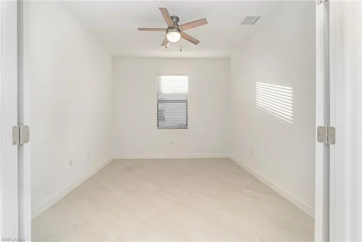 Spare room with baseboards and a ceiling fan