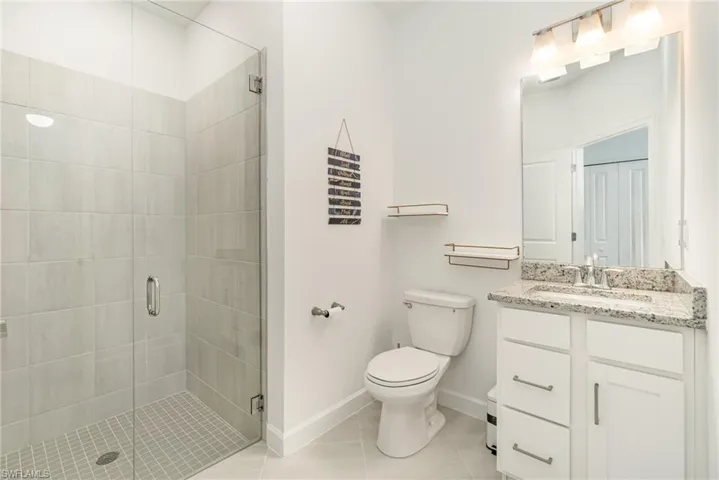 Bathroom featuring vanity, a shower stall, and light tile patterned flooring