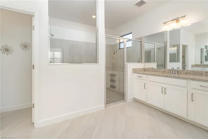 Bathroom featuring vanity, a shower stall, and light tile patterned floors