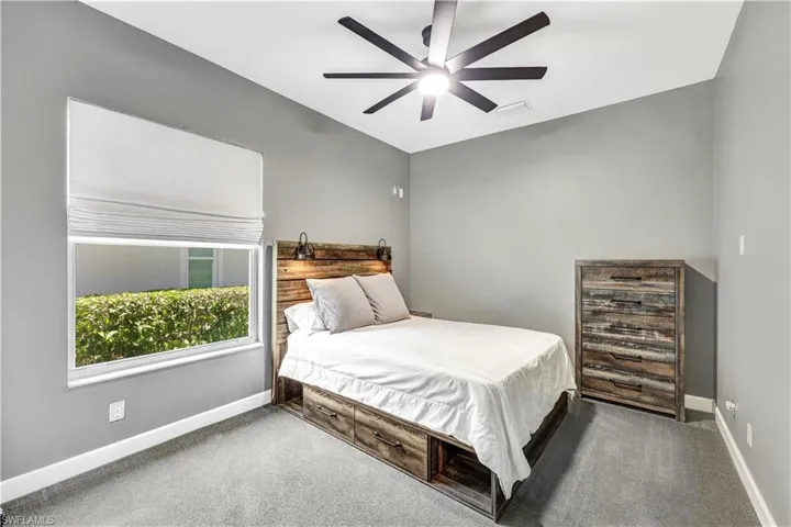 Bedroom with ceiling fan and dark carpet