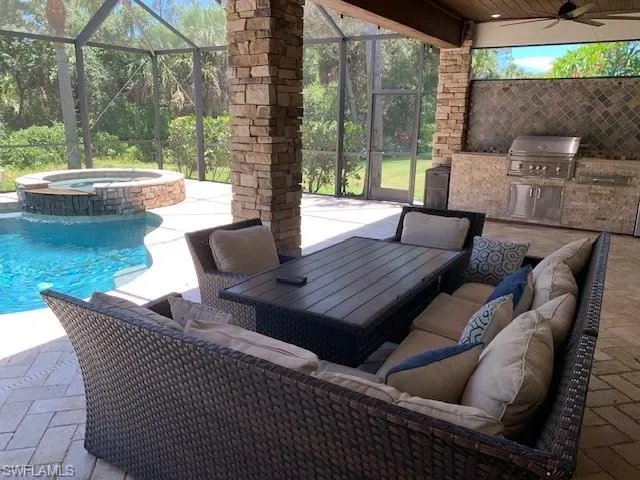 View of patio featuring an outdoor hangout area, a swimming pool with hot tub, grilling area, and ceiling fan