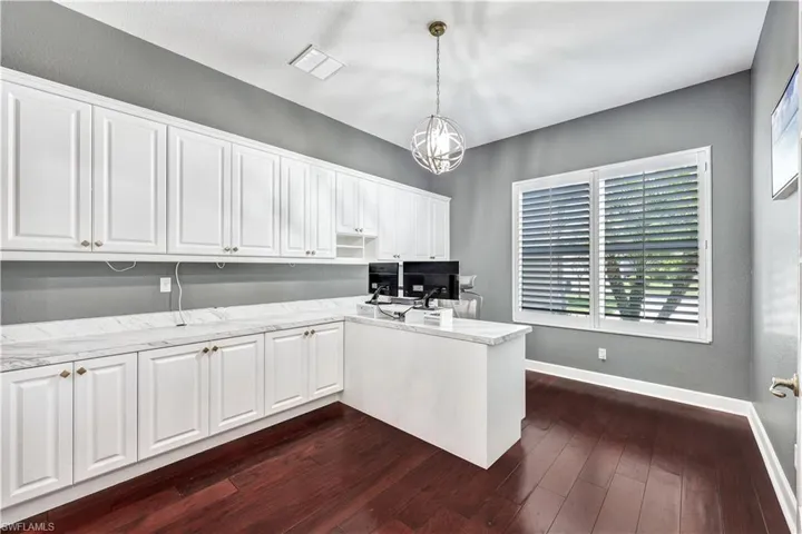 Unfurnished office featuring a chandelier and dark hardwood / wood-style floors. This is the fifth bedroom and has a closet if desired to return to be used as a bedroom.